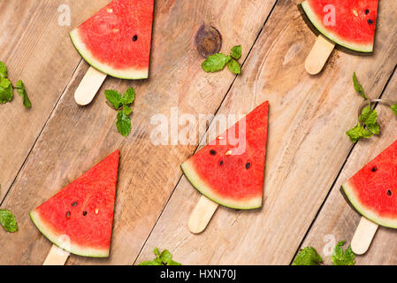 Les tranches de melon sur des bâtons. Popsicle pastèque en bois sur fond blanc. Haut de la vue, télévision lay Banque D'Images