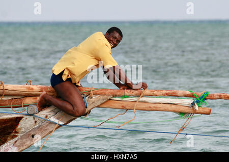 Zanzibar, Tanzanie, 18 février 2008 : Zanzibar, Tanzanie, 18 février 2008 : pêcheur dans yellow T-shirt, fixe en bois petit montage Banque D'Images