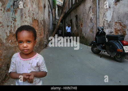 Zanzibar, Tanzanie - le 16 février 2008 : Inconnu enfant africain sur 6 ans, se dresse dans la cour de la maison, avec de vieux murs délabrés. Banque D'Images