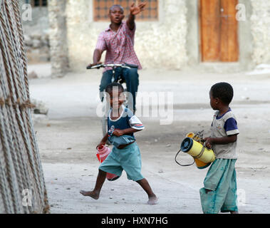 Zanzibar, Tanzanie, 18 février 2008 : deux inconnus African boy sur 8 ans, rendez-vous pour de l'eau transportant les cruches vides. Banque D'Images