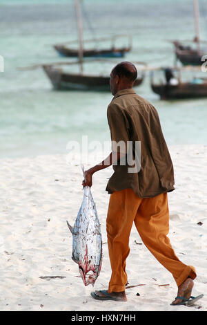 Zanzibar, Tanzanie, 18 février 2008 : Zanzibar, Tanzanie, 18 février 2008 : pêcheur poisson vidé sur la rive et mène à l'océan pour rincer. Banque D'Images