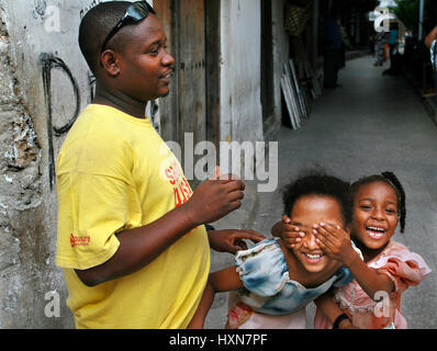 Zanzibar, Tanzanie - Février 16, 2008 : la famille de l'Afrique noire, père de deux enfants, jeunes filles, jouant à la peau sombre, et rire, leur âge approximatif, un 6 Banque D'Images