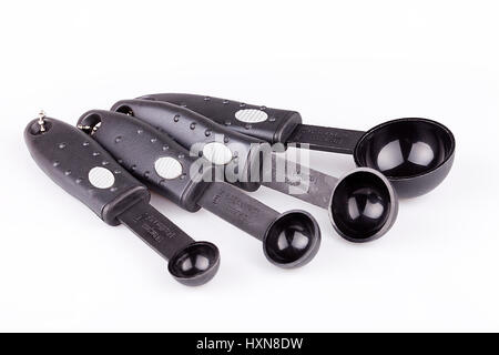 Ensemble de cuillères à mesurer en plastique noir isolé sur fond blanc. Banque D'Images