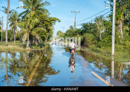 Motorbiker conduite au sud de Hua Hin après de fortes pluies. La saison des pluies en Thaïlande a été retardé en 2016 avec de fortes pluies jusqu'en janvier 2017. Banque D'Images