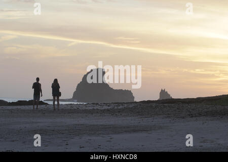 Waling couple sur une plage pendant la golden sunset Banque D'Images