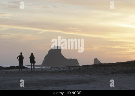 Waling couple sur une plage pendant la golden sunset Banque D'Images