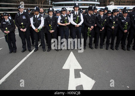 Des milliers de personnes y compris les agents de police et les dirigeants musulmans se sont rassemblés sur le pont de Westminster de tenir une vigile et une minutes de silence une semaine après l'attaque terroriste, le 29 mars 2017 à Londres, Royaume-Uni. Stand de la Police métropolitaine en lignes holding white roses en mémoire de leur collègue et des membres du public. Banque D'Images