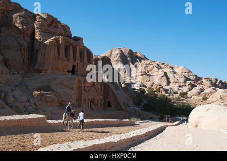 Jordanie : un touriste sur un âne en face de l'Obélisque tombe et Bab As-Siq Triclinium sur la route de la Siq, l'entrée principale de la ville de Petra Banque D'Images