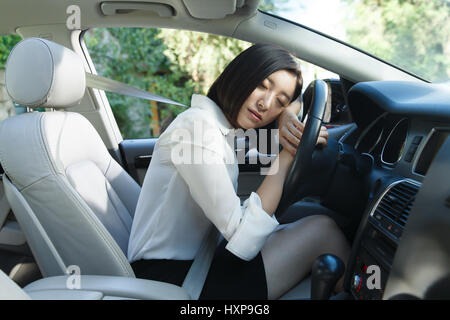 Young woman sleeping in car Banque D'Images