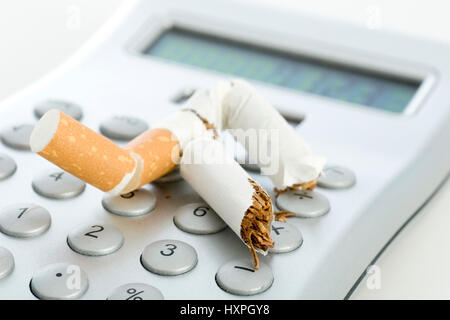 A cigarette sur une calculatrice de poche, ausgedrückte Zigarette auf einem Taschenrechner Banque D'Images
