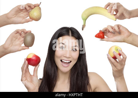 Woman holding fruits et légumes, tourné en studio sur un fond blanc Banque D'Images