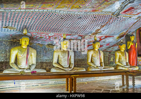 DAMBULLA, SRI LANKA - le 27 novembre 2016 : les statues de pierre de Bouddha méditant entouré par les murales sur les murs et le plafond du Maharaja Lena Cave ( Banque D'Images