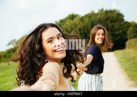 Deux filles exécutant heureux dans la nature se tenant la main. Point de vue tourné. Banque D'Images