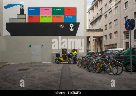 Un facteur, entouré par divers moyens de transport, allant sur son vespa, qui est placé en face d'une peinture murale d'Ugo Guarino. Ville port Trieste, Italie. Banque D'Images