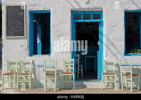 Coffee House, Cafeneion avec porte et fenêtres bleu et vert chaises dans l'île de Schinoussa à midi, Cyclades, Grèce Banque D'Images