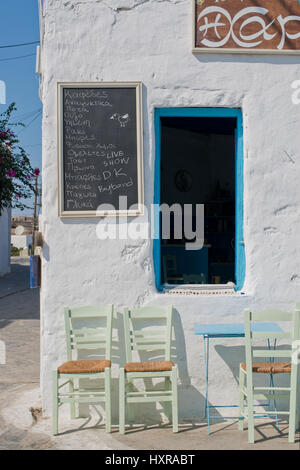 Coffee House, Cafeneion avec porte et fenêtres bleu et vert chaises dans l'île de Schinoussa à midi, Cyclades, Grèce Banque D'Images