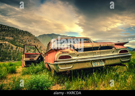 Un vintage rouille Ford Galaxy dans un domaine rural. Banque D'Images