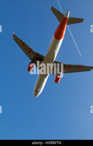 Easyjet Airbus A320 vu du dessous, tandis que l'atterrissage à Manchester. Un autre avion est en laissant une traînée de vapeur blanche au-dessus dans le ciel bleu. Banque D'Images