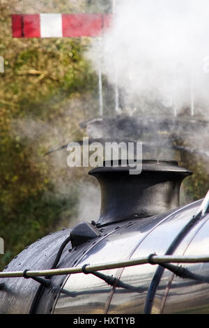 Close up of smoke stack de train à vapeur de fumée émettant vintage signal wit en arrière-plan Banque D'Images