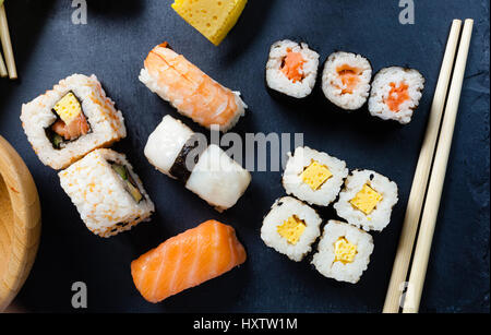 Bac en ardoise noire d'un assortiment de sushi et de rouleaux. Banque D'Images