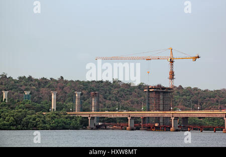 Construction de grands piliers en béton à l'aide de grues à tour, nouveau pont sur la rivière de Mondovi à Goa, Inde Banque D'Images
