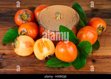 Le kaki kaki composition fruits sur le vieux bois. L'Oriental nature morte. Banque D'Images