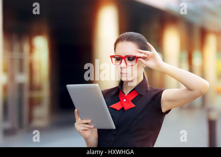 Mécontentement Businesswoman with PC Tablet et lunettes rouges Banque D'Images