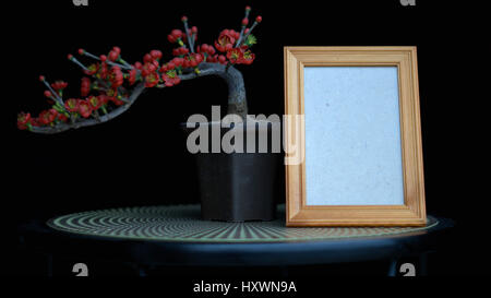 Cadre vide ou vide photo frame de personne disparue avec bonsai fleurs rouges Banque D'Images