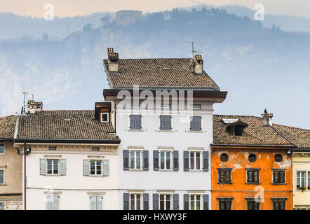 Trento, Italie - 21 mars 2017 : rangée de maisons avec des façades sur la place Duomo Pizza, avec les Alpes à l'arrière. Banque D'Images