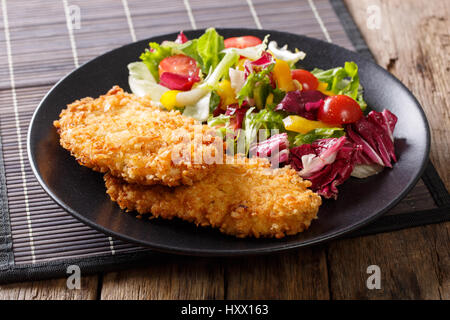 Délicieux steak dans la chapelure Panko et salade de légumes frais sur la table horizontale. Banque D'Images