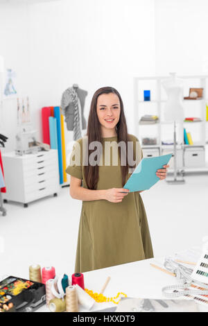 Jeune étudiant designer smiling et debout devant le bureau dans l'atelier Banque D'Images