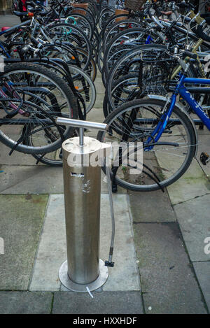 Parc à vélos public avec pompe à pneus en acier offrant l'air libre Cambridge Angleterre Banque D'Images