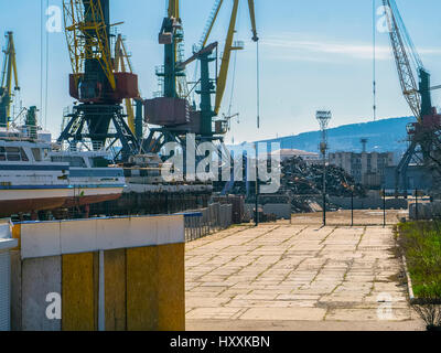 Grues du port et un tas de ferraille Banque D'Images