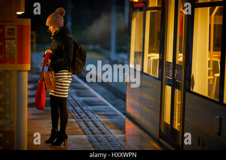 L'aube d'un matin de tramway Metrolink banlieue achète son billet passager plate-forme à la machine, la station Didsbury à Parrswood Banque D'Images