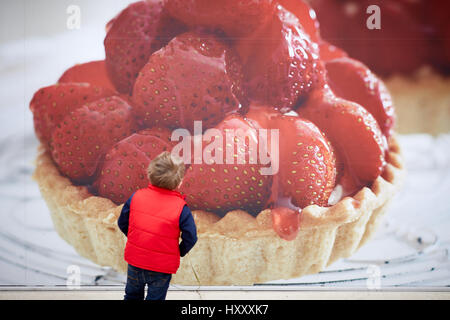 Petit enfant à la tarte aux fraises à l'affiche de la publicité. Banque D'Images