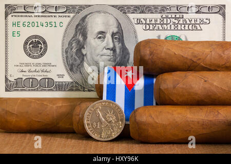 Cigares Cubains de luxe avec des billets et pièces en dollars US sur la table en bois. Banque D'Images