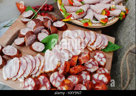 Saucisses différentes sur planche de bois au mariage de traiteur. Banque D'Images