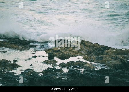 Vagues se brisant sur le rivage au coucher du soleil. Thor est bien, Cape Perpetua, Oregon, USA. Banque D'Images