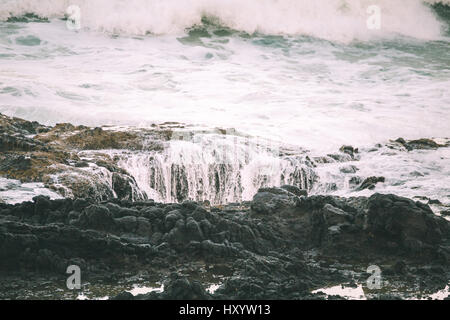 Vagues se brisant sur le rivage au coucher du soleil. Thor est bien, Cape Perpetua, Oregon, USA. Banque D'Images