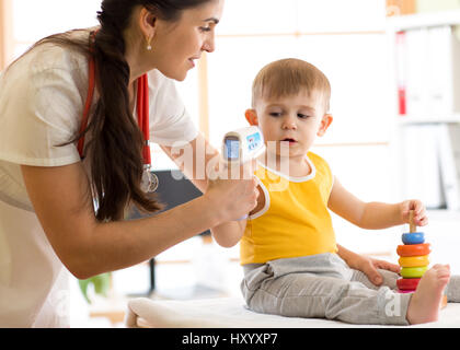 Mesure de la température médecin cute kid Banque D'Images