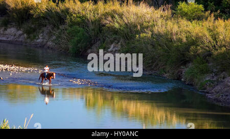 L'homme du Mexique sur des randonnées à cheval à travers le fleuve Rio Grande Big Bend National Park Banque D'Images