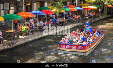 Bateau d'excursion plein de touristes envahit la rivière San Antonio à la rivière à pied à San Antonio, Texas Banque D'Images