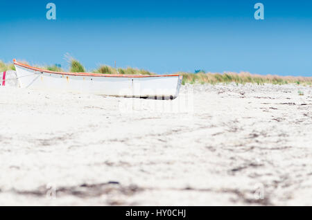 Petit bateau blanc sur la plage de sable Banque D'Images