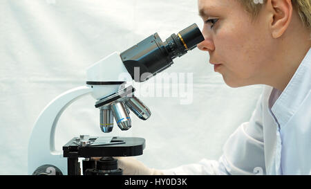 Femme médecin à la recherche scientifique par le biais de microscope Banque D'Images