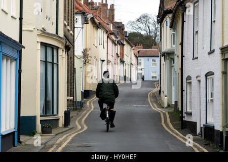 Un cycliste à High Street, Wells-next-the-Sea, Norfolk, England, UK Banque D'Images