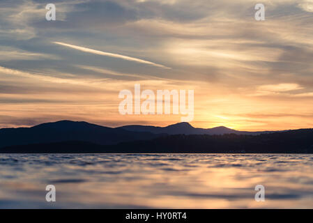 Coucher de soleil depuis la troisième plage à Vancouver (Stanley Park), C.-B., Canada. Les montagnes de l'océan, silhouette et beau ciel avec quelques nuages. Banque D'Images