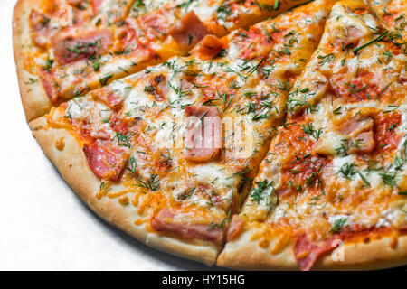 Pizza au jambon, par couper en morceaux sur une table en métal. selective focus sur le remplissage de près. Banque D'Images