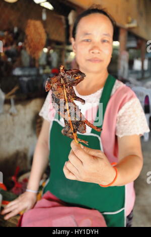 Pak Nam Noy, Laos-October 8, 2015 : femme locale vend aux pilotes en passant par les rats grillés sur des brochettes de bambou dans un restaurant routier à la 1A-2E-H13 routes principales Banque D'Images