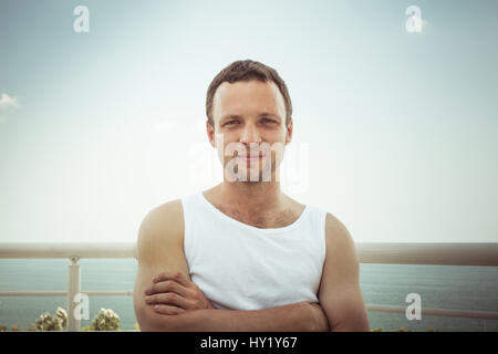 Portrait d'été en plein air de Young smiling homme européen en chemise blanche, photo aux tons vintage Banque D'Images