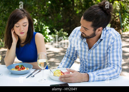 Jeune couple ayant des difficultés relationnelles au restaurant en plein air Banque D'Images